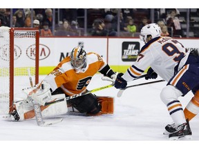 Philadelphia Flyers' Carter Hart, left, blocks a shot by Edmonton Oilers' Connor McDavid during the first period of an NHL hockey game, Saturday, Feb. 2, 2019, in Philadelphia.