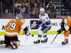 Philadelphia Flyers' Carter Hart (79) blocks a shot by Vancouver Canucks' Tyler Motte (64) as Shayne Gostisbehere (53) defends during the first period of an NHL hockey game, Monday, Feb. 4, 2019, in Philadelphia.