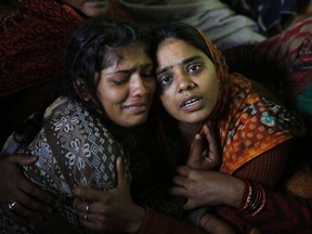 Sanju, right, and Sanjana, wife and sister respectively of paramilitary soldier Mahesh Yadav, who was killed in Thursday's explosion in Kashmir, mourn at their home in Tudihar, some 56 kilometers east of Prayagraj, Uttar Pradesh state, India, Saturday, Feb. 16, 2019. The death toll from a car bombing on a paramilitary convoy in Indian-controlled Kashmir has climbed to at least 40, becoming the single deadliest attack in the divided region's volatile history, security officials said Friday.