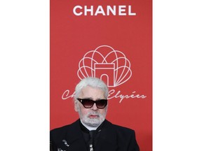 FILE - In this hursday, Nov. 22, 2018 file photo, Karl Lagerfeld poses during the Champs Elysee Avenue illumination ceremony for the Christmas season, in Paris. Chanel's iconic couturier, Karl Lagerfeld, whose accomplished designs as well as trademark white ponytail, high starched collars and dark enigmatic glasses dominated high fashion for the last 50 years, has died. He was around 85 years old.