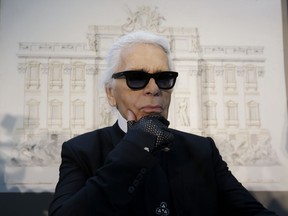 FILE - In this Monday, Jan. 28, 2013 file photo, Karl Lagerfeld poses for photographers prior to the start of a press conference, in Rome. Chanel's iconic couturier, Karl Lagerfeld, whose accomplished designs as well as trademark white ponytail, high starched collars and dark enigmatic glasses dominated high fashion for the last 50 years, has died. He was around 85 years old.