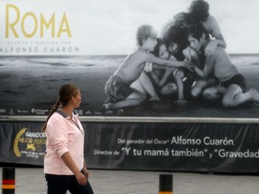 A woman looks at a banner hanging from the "Roma Mobile Cinema" in Zapopan, Mexico, on February 22, 2019.