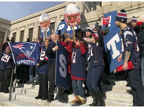 Workers at Boston's Museum of Fine Arts rally outside in New England Patriots garb on Friday, Feb. 1, 2019 in Boston. The museum and Los Angeles' J. Paul Getty Museum are trading a little trash talk ahead of the Super Bowl between the Patriots and the Rams.