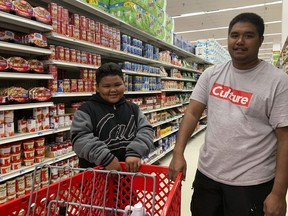 Tyrone Quinata, 23, and his nephew Rayden Gofigan, 11, shop for batteries and other necessities in Tamuning, Guam on Thursday, Feb. 21, 2019.  An intensifying tropical storm in the Pacific is bearing down on Micronesia and could threaten the U.S. territory of Guam in the coming days.