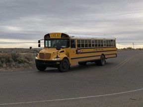 A school bus evacuates students from Sue V. Cleveland High School in Rio Rancho, New Mexico, on Thursday, Feb. 14, 2019, after a shot was fired on the campus. Police and school officials said no one was injured and a suspect was taken into custody.