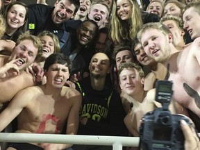 Golden State Warriors' Stephen Curry, center, poses with the Davidson College swim team as he takes in an NCAA college basketball game at his alma mater  Friday, Feb. 15, 2019,  while back in his hometown of Charlotte, N.C., for the NBA basketball All-Star game.