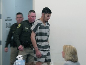 Wilber Martinez-Guzman is escorted into Carson City Justice Court on Friday, Feb. 8, 2019, before his preliminary hearing was postponed on multiple counts stemming from his alleged murder of four people in northern Nevada last month. The 20-year-old Salvadoran immigrant waived his right to speedy proceedings in Carson City on burglary charges related to items stolen from some of the victims. Prosecutors say he's expected to be extradited to Reno next week to face four murder counts first.