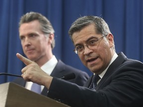 California Attorney General Xavier Becerra, right, accompanied by Gov. Gavin Newsom, said California will probably sue President Donald Trump over his emergency declaration to fund a wall on the U.S.-Mexico border Friday, Feb. 15, 2019, in Sacramento, Calif. Becerra says there is no emergency at the border and Trump doesn't have the authority to make the declaration.