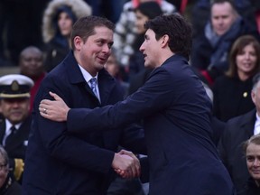 Prime Minister Justin Trudeau (right) greets Federal Conservative Leader Andrew Scheer at a vigil.