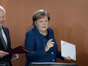 Vice Chancellor Olaf Scholz, left, and German Chancellor Angela Merkel, right, arrive for the weekly cabinet meeting at the Chancellery in Berlin, Germany, Wednesday, Feb. 6, 2019.