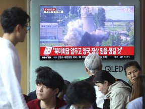 A TV screen shows file footage of the demolition of the 60-foot-tall cooling tower at its main reactor complex in Yongbyon, North Korea, on June 27, 2008 during a news program at the Seoul Railway Station in Seoul, South Korea, Sunday, May 13, 2018.