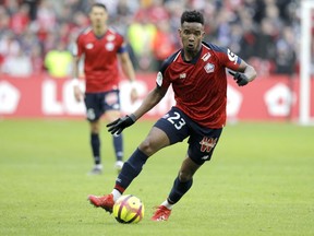 Lille's Thiago Mendes in action, center, controls the ball during the French League One soccer match between Lille and Montpellier at the Lille Metropole stadium, in Villeneuve d'Ascq, northern France, Sunday, Feb. 17, 2019.