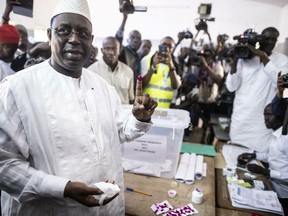 FILE - In this Sunday Feb. 24, 2019 file photo Senegal's incumbent President Macky Sall casts his vote during the presidential election at a polling station in Fatick, Senegal. Senegal's electoral commission says that President Macky Sall has won a second term in office with more than 58 percent of the vote. It was not immediately clear if the top opposition candidates would accept the results announced Thursday afternoon. (AP Photo, File)