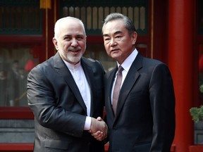 Iranian Foreign Minister Mohammad Javad Zarif, left, and his Chinese counterpart Wang Yi shake hands during their meeting at the Diaoyutai State Guesthouse in Beijing Tuesday, Feb. 19, 2019.