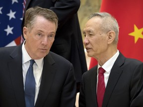 FILE - In this Feb. 15, 2019, file photo, Chinese Vice Premier Liu He, right, talks with U.S. Trade Representative Robert Lighthizer, while they line up for a group photo at the Diaoyutai State Guesthouse in Beijing. China's economy czar is going to Washington for talks Thursday and Friday aimed at ending a tariff war over Beijing's technology ambitions.