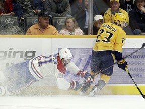 Montreal Canadiens center Nate Thompson (21) tries to slow down Nashville Predators center Rocco Grimaldi (23) in the first period of an NHL hockey game Thursday, Feb. 14, 2019, in Nashville, Tenn.