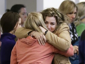 CORRECTS TO RECKLESS HOMICIDE, NOT CRIMINAL HOMICIDE- RaDonda Vaught, center, is hugged by a supporter outside a courtroom before Vaught's hearing Wednesday, Feb. 20, 2019, in Nashville, Tenn. Vaught, a former nurse at Vanderbilt University Medical Center, is charged with reckless homicide after a medication error killed a patient. A number of nurses showed up to support Vaught.