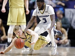 Wofford guard Ryan Larson (11) battles for the loose ball with Chattanooga guard David Jean-Baptiste (3) during the first half of an NCAA college basketball game Thursday, Feb. 28, 2019, in Chattanooga, Tenn.