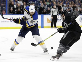 Tampa Bay Lightning center Tyler Johnson (9) steals the puck from St. Louis Blues center Ryan O'Reilly (90) during the first period of an NHL hockey game Thursday, Feb. 7, 2019, in Tampa, Fla.