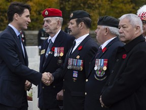 Canadian Prime Minister Justin Trudeau speaks with Canadian veterans following a ceremony at the Canadian Cemetery No. 2 near Vimy Ridge, France in 2018.