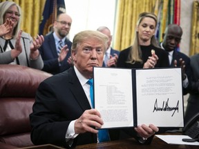 U.S. President Donald Trump displays the signed Space Policy Directive 4 during a ceremony in the Oval Office of the White House in Washington, D.C., U.S., on Tuesday, Feb. 19, 2019. Trump signed a directive to establish a U.S. Space Force, saying that it needed to be formed because adversaries are in space.