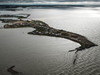 The last remaining homes on Beaufort Drive in Tuktoyaktuk, N.W.T., can be seen in the centre of this photo of the Beaufort Sea coastline.