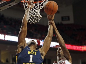 Texas Tech's Tariq Owens (11) fouls West Virginia's Derek Culver (1) as he shoots the ball during the first half of an NCAA college basketball game Monday, Feb. 4, 2019, in Lubbock, Texas.