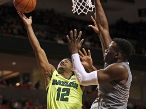 Baylor's Jared Butler (12) lays up the ball around Texas Tech's Norense Odiase (32) during the first half of an NCAA college basketball game Saturday, Feb. 16, 2019, in Lubbock, Texas.