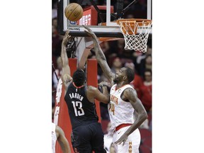 CORRECTS YEAR TO 2019 NOT 2018 - Houston Rockets guard James Harden (13) shoots as Atlanta Hawks guard Kent Bazemore defends during the first half of an NBA basketball game, Monday, Feb. 25, 2019, in Houston.