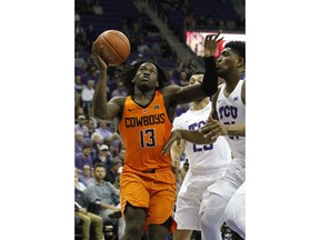 Oklahoma State guard Isaac Likekele (13) drives to the basket, defended by TCU guard Alex Robinson (25) and center Kevin Samuel (21) during the first half of an NCAA college basketball game, Wednesday, Feb. 6, 2018 in Fort Worth, Texas.