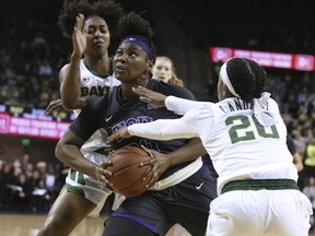 TCU forward Amy Okonkwo, center, drives between Baylor guard Didi Richards, left, and guard Juicy Landrum, right, during the first half of an NCAA college basketball game, Saturday, Feb. 9, 2019, in Waco, Texas.