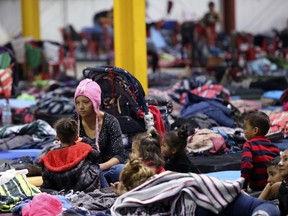 Honduran Delia Romero, 24, sits with her children in their sleeping area at a sheltered in Piedras Negras, Mexico, Tuesday, Feb. 5, 2019. A caravan of about 1,600 Central American migrants camped Tuesday in the Mexican border city of Piedras Negras, just west of Eagle Pass, Texas. The governor of the northern state of Coahuila described the migrants as "asylum seekers," suggesting all had express intentions of surrendering to U.S. authorities.