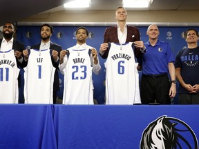 Dallas Mavericks' Tim Hardaway Jr. (11), Courtney Lee (1), Trey Burke (23) and Kristaps Porzingis (6) pose with their new jerseys along side head coach Rick Carlisle, second from right, and team owner Mark Curban, right, during a news conferences where the newly acquired players were introduced in Dallas, Monday, Feb. 4, 2019.