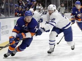 Toronto Maple Leafs center John Tavares (91) checks New York Islanders center Mathew Barzal (13)with his stick during the first period of an NHL hockey game Thursday, Feb. 28, 2019, in Uniondale, N.Y.