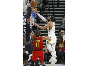 Utah Jazz guard Ricky Rubio, right, lays the ball up as Atlanta Hawks guard Trae Young (11) defends during the first half of an NBA basketball game Friday, Feb. 1, 2019, in Salt Lake City.