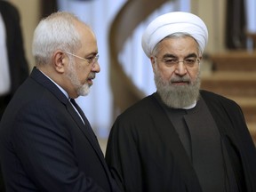 FILE- In this Nov. 24, 2015, file photo, Iranian President Hassan Rouhani, right, listens to his Foreign Minister Mohammad Javad Zarif prior to a meeting in Tehran, Iran. On Monday Feb. 25, 2019, Iran's state-run IRNA news agency reported that Foreign Minister Mohammad Javad Zarif has resigned.