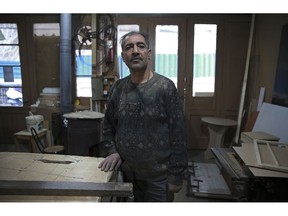 In this Tuesday, Jan. 22, 2019 photo, carpenter Mohammad Reza Tajik is interviewed by The Associated Press about Iran's 1979 Islamic Revolution at his workshop, in northern Tehran, Iran. Forty years after he defected from the shah's Imperial Guard to join the Islamic Revolution, Tajik, like many Iranians from that time, looks back wistfully at the youthful excitement they felt and the losses they suffered since then.