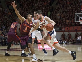 Virginia guard Ty Jerome (11) dribbles past Virginia Tech defender Wabissa Bede (3) during the first half of an NCAA college basketball game in Blacksburg, Va., Monday, Feb. 18, 2019.