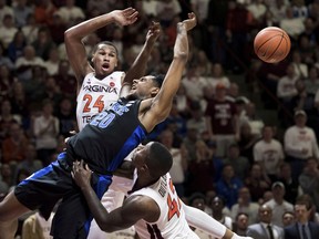 Duke center Marques Bolden (20) is fouled as Virginia Tech's Kerry Blackshear Jr. (24) and Ty Outlaw (42) defend during the first half of an NCAA college basketball game in Blacksburg, Va., Tuesday, Feb. 26, 2019.