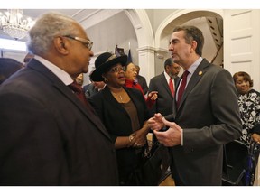 Virginia Gov. Ralph Northam greets, a member of the Richmond 34, Leroy Bray and his wife Cynthia, center, for a breakfast at the Governors Mansion at the Capitol in Richmond, Va., Friday, Feb. 22, 2019. The Richmond 34 were a group of African Americans who defied segregation laws in the 1960's