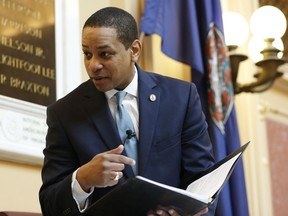 Virginia Lt. Gov Justin Fairfax looks over a briefing book prior to the start of the senate session at the Capitol in Richmond, Va., Thursday, Feb. 7, 2019. A California woman has accused Fairfax of sexually assaulting her 15 years ago.