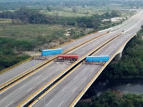 A fuel tanker, cargo trailers and makeshift fencing block the Tienditas International Bridge in an attempt to stop humanitarian aid entering Venezuela from Colombia, Feb. 6, 2019.