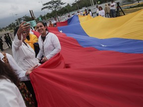 Demonstrators and medical professionals take a selfie photograph during a protest against the blocking of humanitarian aid at the Tienditas International Bridge in Cucuta, Colombia, on Sunday, Feb. 10, 2019.