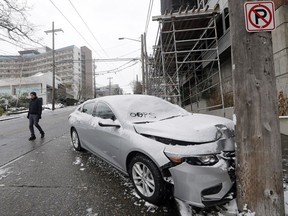 A crashed car sits at the bottom of one of Seattle's steeper hills on an ice-slicked road in the Queen Anne neighborhood, Monday, Feb. 4, 2019. Western Washington was hit by a major winter storm, with several inches of snow, cold temperatures and bone-chilling winds overnight and into the day Monday.