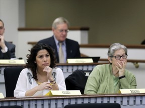 Rep. Monica Stonier, D-Vancouver, lower left, and Rep. Laurie Jenkins, D-Tacoma, right, listen Friday, Feb. 8, 2019, during a public hearing before the House Health Care & Wellness Committee at the Capitol in Olympia, Wash. Amid a measles outbreak that has sickened people in Washington state and Oregon, lawmakers heard public testimony Friday on a bill that would remove parents' ability to claim a philosophical exemption to opt their school-age children out of the combined measles, mumps and rubella vaccine.