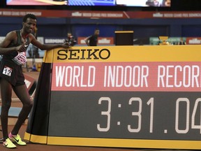 Ethiopia's Samuel Tefera poses next to teh time indicator, as he celebrates getting the mens 1500 metre World Indoor Record during the Muller Indoor Grand Prix in Birmingham, England, Saturday Feb. 16, 2019.