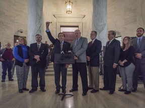 American Federation of Teachers West Virginia Treasurer Fred Albert, fist raised, and other union leaders of the WVEA, AFT-WV and WVSSPA call for a statewide strike beginning tomorrow during a news conference outside of the Senate chamber at the West Virginia State Capitol in Charleston, W.Va., on Monday, Feb. 18, 2019.