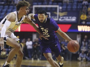TCU guard Alex Robinson (25) drives while defended by West Virginia forward Emmitt Matthews Jr. (11) during the first half of an NCAA college basketball game Tuesday, Feb. 26, 2019, in Morgantown, W.Va.
