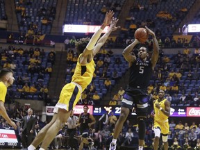 Kansas State guard Barry Brown Jr. (5) shoots while defended by West Virginia forward Emmitt Matthews Jr. (11) during the first half of an NCAA college basketball game Monday, Feb. 18, 2019, in Morgantown, W.Va.