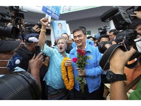 Leader of Democrat party Abhisit Vejjajiva, center right, is greeted by supporters as he arrives for the registration of constituency candidates competing in upcoming general election at Thailand-Japan Youth Center stadium in Bangkok, Thailand, Monday, Feb. 4, 2019. Candidates in Thailand's first general election since the military seized power almost five years ago, began registering on Monday.